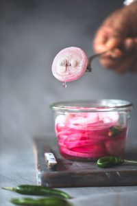 Khatta pyaaz is pickled onions.Onion pickled in vinegar or lemon juice ending in beautiful, tangy, sweet onions. A perfect accompaniment with Indian dishes.