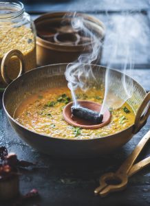 Pressure cook the dal with haldi. Crush garlic, ginger and greenchillies into a coarse paste . Method Heat ghee in a heavy bottom pan. Add jeera and mustard seeds to this. When it turns brown add ginger garlic chilly paste and saute till it turns brown. Add chopped onions and saute till it turns gold. Add chopped tomatoes to this and fry till the tomatoes soften. Add red chilly powder and salt to this and fry for a minute. To this add the cooked dal. Stir well. Add 2 cups of water, salt to taste and boil till it reaches a creamy consistency. Place the coal on the flame directly for a couple of minutes till is red hot. Place a small plate on top of the dal and place the hot coal on it. Pour half a tsp of ghee over the coal and immediately close the pan with a lid. Let the smoke flavour the dal well. I leave it till the smoke completely settles down into the food. Add lemon juice and coriander leaf to the dal and give it a good mix. For tempering add jeera to hot ghee in a pan. Once it turns brown, add red chilly to it. Pour it on the dal. Serve it hot with rice or roti. *Basic way to make this dal is to make a tempering of ghee, jeera, red chillies, hing and add the cooked dal to it and season it with salt. Garnish it with coriander leaves and lemon juice.