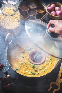 Pressure cook the dal with haldi. Crush garlic, ginger and greenchillies into a coarse paste . Method Heat ghee in a heavy bottom pan. Add jeera and mustard seeds to this. When it turns brown add ginger garlic chilly paste and saute till it turns brown. Add chopped onions and saute till it turns gold. Add chopped tomatoes to this and fry till the tomatoes soften. Add red chilly powder and salt to this and fry for a minute. To this add the cooked dal. Stir well. Add 2 cups of water, salt to taste and boil till it reaches a creamy consistency. Place the coal on the flame directly for a couple of minutes till is red hot. Place a small plate on top of the dal and place the hot coal on it. Pour half a tsp of ghee over the coal and immediately close the pan with a lid. Let the smoke flavour the dal well. I leave it till the smoke completely settles down into the food. Add lemon juice and coriander leaf to the dal and give it a good mix. For tempering add jeera to hot ghee in a pan. Once it turns brown, add red chilly to it. Pour it on the dal. Serve it hot with rice or roti. *Basic way to make this dal is to make a tempering of ghee, jeera, red chillies, hing and add the cooked dal to it and season it with salt. Garnish it with coriander leaves and lemon juice.