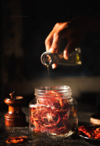 Once the tomatoes are well dried, store some of them in a zip loc bag for later use. Add the remaining into a jar and the Italian seasoning to it. Now pour the olive oil till all the tomatoes are covered in the oil. Give it a good shake and set them aside for a week so that the tomatoes soak up some of the oil. You can used this in pastas and salads and the oil in the dressing.