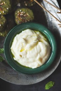 1 cup - Chana dal1/2 cup - fresh Coriander leaves1 - small onion, quartered2 Tbsp - Ginger garlic cloves, peeledSalt to taste1 Tbsp ground cumin1 Tbsp - Paanch phoran3 - Green chilliesSalt to taste2 Tbsp toasted sesame seeds1 tsp - Chilly flakes Soak chana dal in water for at least 4 hours. When ready, drain the dal completely and pat them dry.Add the coriander, cumin, onions, ginger garlic paste, green chillies, paanch phoranto Hamilton Beache’s small jar. Set on preset wet hard + coarse run the blender till all the ingredients cometogether. You may have to scrape the sides of the jar to help it blend evenly. Transfer the tikki mixture to a container and cover tightly. Refrigerate for at least 1 hour or until ready to cook.Preheat the oven to 180º C.Line the tray with baking paper.Add sesame seeds to the tikki mixture and stir with a spoon.Scoop tablespoonfuls of the tikki mixture and form into patties (½ inch in thickness each). Place the patties on the baking tray and sprinkle sesame seeds and chilly flakes on top.Bake for 15 mins on each side. Brush it with melted butter before flipping it.  Once they are brown enough take them out and servethem with the Garlic Dip.